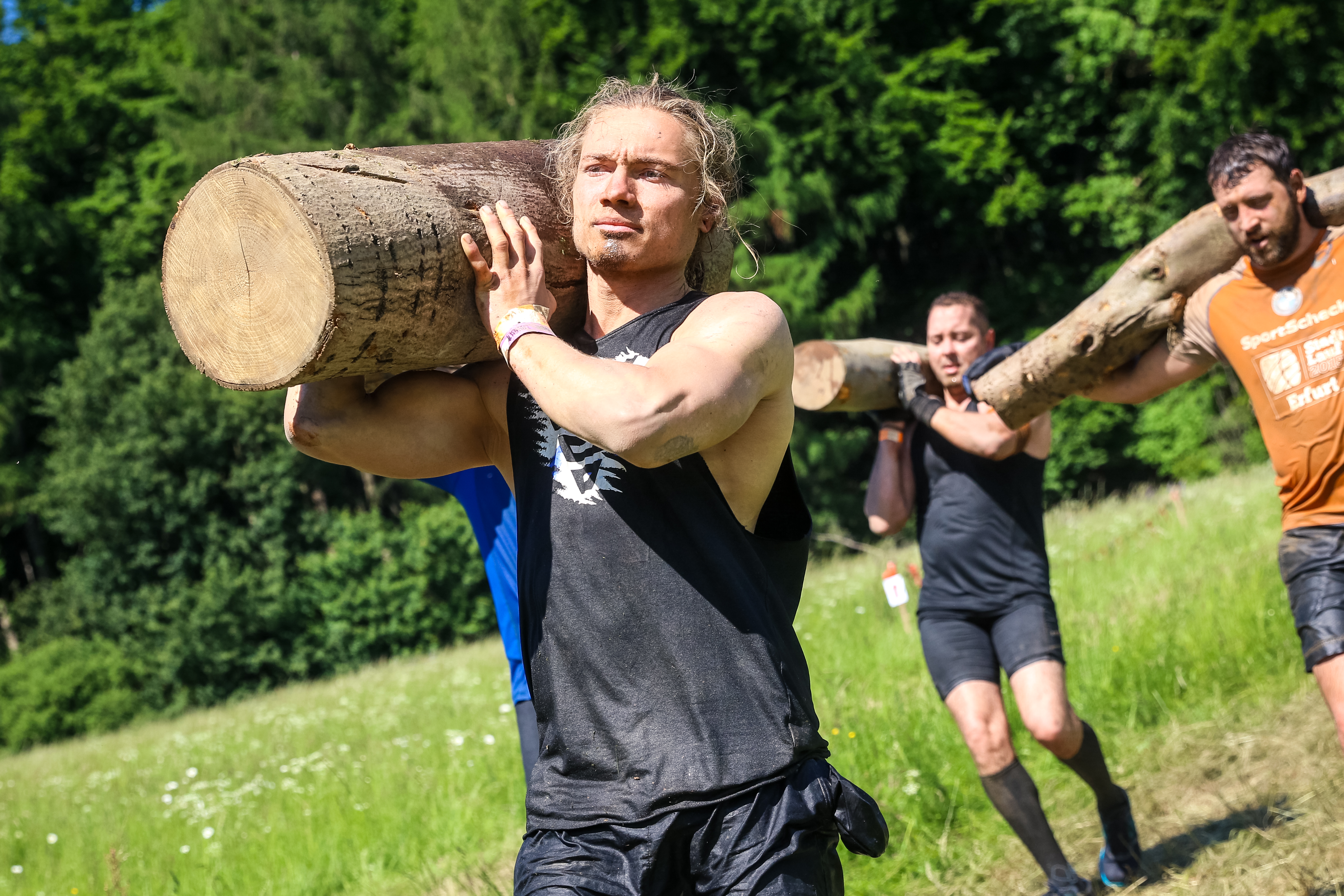 Participants carrying logs of wood