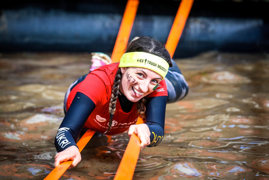 Participant smiling while carefully crawling on the rope