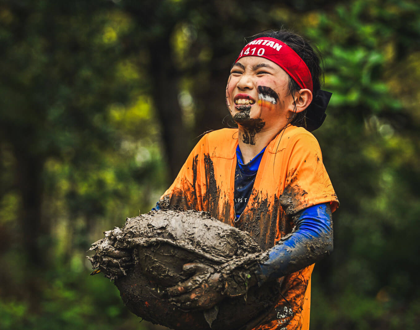 A kid struggling to carry a big rock